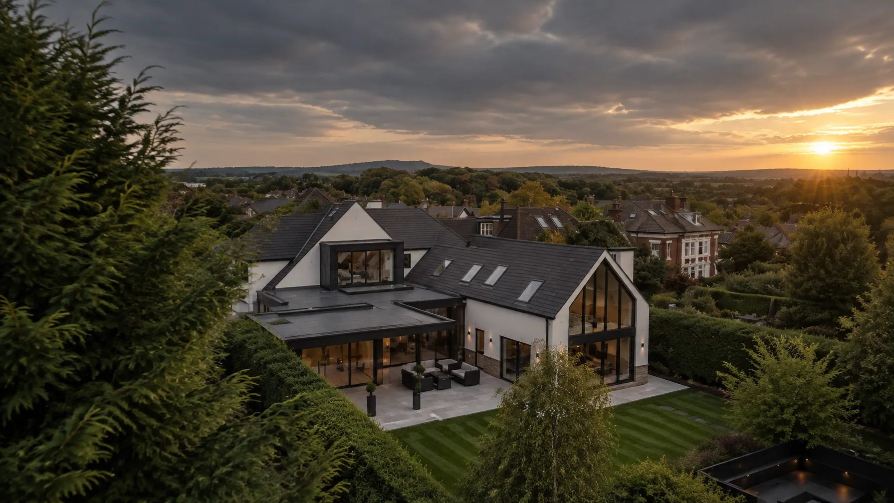 Finished contemporary home surrounded by trees at sunset